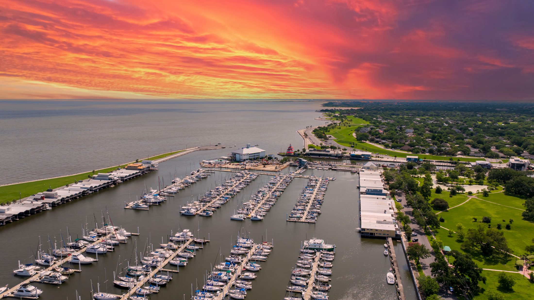 Aerial view of a marina full of boats under a golden sunset sky